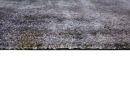 Nahaufnahme eines grauen, flauschigen Teppichs auf weißem Hintergrund, weiche Textur, moderner Wohnstil.