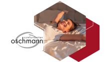 Frau streckt sich glücklich auf einem oschmann Comfortbett – Aufwachen mit einem Lächeln dank maximalem Schlafkomfort