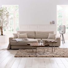 Helles Wohnzimmer im Scandi-Boho-Style mit Couch in Beige und strukturierenden Elementen wie Gestellen in Schwarz