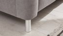 Graues Sofa mit Metallfuß auf hellem Holzfußboden neben einem Teppich, modernes Wohnzimmer-Design.