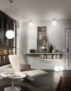 Modernes Wohnzimmer mit weiu00dfem Ledersessel, Bu00fccherregal, runder Lampe und grou00dfem Fenster mit Stadtblick bei Nacht.