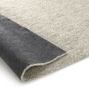 Beiger Teppich mit rutschfester, dunkler Unterseite, Nahaufnahme, moderne Wohntextilien, Teppichdetail.