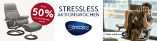 Banner zu den Stressless Aktionswochen mit Abbildung eines grauen Stressless-Sessels mit Hocker und dem Hinweis „Bis zu 50 % auf Ausstellungsstücke“, mittig das Stressless-Logo, rechts ein Mann entspannt im Sessel mit Button „Mehr erfahren“.