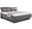 Modernes Boxspringbett in Grau mit Kopfteil, weißer Matratze und gemustertem Bettüberwurf im Schlafzimmer.