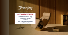 Moderner Stressless-Relaxsessel in hellem Raum mit Holzvertäfelung, Aktionswochen-Schild und Bücherregal.