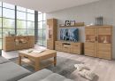 Vitrine Cortina L Eiche 58 cm Modernes Wohnzimmer mit großen Fenstern, Holzmöbeln, TV, Couchtisch und dekorativen Accessoires auf Teppich.