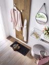 Moderner Flur mit Holz-Garderobe, rosa Blazer, Schuhen, Spiegel, Tulpen, Hocker und Handtasche auf Holzboden.