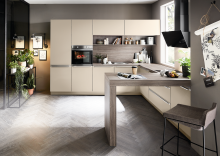 Moderne, helle Einbauküche mit Holzdekor, Kücheninsel, Pflanzen, großen Fenstern und stilvoller Dekoration.