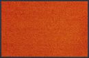 Orangefarbener Teppich mit feiner Struktur, rechteckig, moderne Wohnraumdekoration, Nahaufnahme.