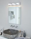 Modernes Badezimmer mit Steinwaschbecken, Wandspiegel, LED-Lampe und stilvollen Accessoires auf weißer Ablage.