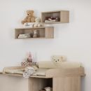 Holz-Wickelkommode mit weichem Wickelauflage, Stofftieren und Regalen im modernen Babyzimmer.