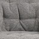 Grau gepolsterte Stoffoberfläche eines Sofas mit strukturierter Textur und sichtbaren Nähten.