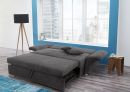 Graues Schlafsofa mit ausgezogener Liegefläche in modernem Wohnzimmer mit Stadtblick und stilvoller Einrichtung.