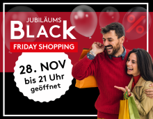 Junges Paar mit Einkaufstaschen beim Black Friday Jubiläums-Shopping, geöffnet bis 21 Uhr am 28. November.