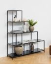 Modernes, schwarzes Metallregal mit Deko, Büchern, Pflanzen und Keramik auf Parkettboden vor weißer Wand.