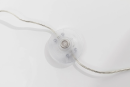 Transparenter Kippschalter für Lampen an silbernem Kabel auf weißem Hintergrund, Detailaufnahme.