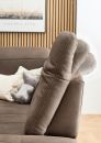 Braunes Sofa mit verstellbarer Rückenlehne, Kuscheltier-Elefant und Kissen vor Holz-Wand und Wandbild.