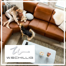 Frau mit Kind und Hund auf braunem Ledersofa von W.Schillig im modernen Wohnzimmer mit Tageslicht.