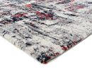 Moderner Teppich mit abstraktem Muster in Grau, Rot und Blau, weiche Oberfläche, Nahaufnahme der Ecke.