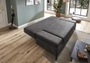 Graues Schlafsofa im modernen Wohnzimmer mit Holzfußboden, großen Fenstern und stilvoller Dekoration.