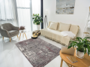 Helles Wohnzimmer mit Sofa, Teppich, Sessel, Gitarre, Pflanzen, Laptop und moderner Wandkunst.