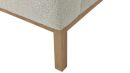 Nahaufnahme eines Holzbein-Sofas mit cremefarbenem Bouclé-Stoffbezug, modernes Möbel-Design.