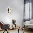 Moderne LED-Wandleuchte in Schwarz und Gold mit geschwungenem Design, energiesparend, für Wohnzimmer.