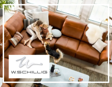 Frau und Kind spielen mit Hund auf braunem Ledersofa von W.Schillig im modernen, hellen Wohnzimmer.