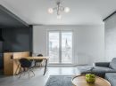 Modernes Wohnzimmer mit grauem Sofa, Holztisch, Essbereich und Panoramafenster mit Stadtblick.