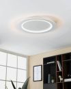 Moderne LED-Deckenleuchte leuchtet in hellem Raum mit Bücherregal, Fenster und Wandbild im Hintergrund.