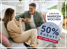 Paar trinkt Kaffee auf Sofa, lächelt sich an, Werbebanner für Jubiläums Markenwochen mit bis zu 50% Rabatt.