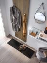 Moderner Flur mit Mantel, Schal, Spiegel, Ablage, Schuhen auf Teppich und heller Holzboden, skandinavisch eingerichtet.