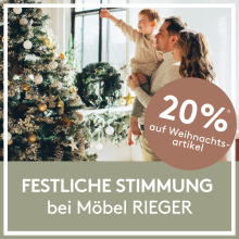 Familie dekoriert Weihnachtsbaum im Wohnzimmer, festliche Stimmung, 20% Rabatt auf Weihnachtsartikel bei Möbel RIEGER.