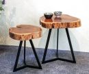 Zwei Couchtische aus Massivholz mit Baumkante und schwarzen Metallbeinen, dekoriert mit Keramikschalen.