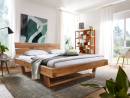 Modernes Schlafzimmer mit Holz-Doppelbett, Bücherregal, großen Fenstern und stilvoller Dekoration im Tageslicht.