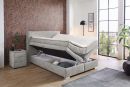 Modernes Boxspringbett mit praktischem Bettkasten, grauem Stoffbezug und gemütlicher Schlafzimmer-Einrichtung.