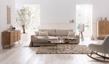 Helles Wohnzimmer im Scandi-Boho-Style mit Couch in Beige und strukturierenden Elementen wie Gestellen in Schwarz