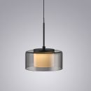 Moderne Hängelampe mit schwarzem Gestell und rundem, rauchgrauem Glas, leuchtet warm auf grauem Hintergrund.
