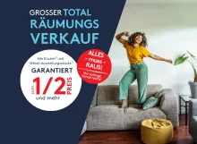 Junge Frau tanzt fröhlich auf Sofa im Wohnzimmer, Werbung für großen Totalräumungsverkauf mit Rabatten.