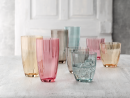 Bunte Trinkgläser aus Glas auf weißem Tisch, modernes Design, einige Gläser mit Eiswürfeln, stilvolle Deko.