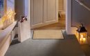 Eingangsbereich mit Fußmatte, Einkaufstasche, Weihnachtsdeko, Kerzenlaterne und festlicher Beleuchtung.