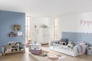 Modernes, helles Kinderzimmer mit Babybett, Spielzeug, Deko, blauer Wand und Holzregalen im skandinavischen Stil.
