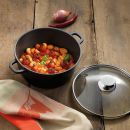 Gnocchi mit Tomatensauce, Basilikum und Kirschtomaten in einem schwarzen Topf auf rustikalem Holztisch.