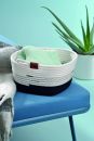 Geflochtener Aufbewahrungskorb mit Handtuch auf blauem Stuhl, daneben Aloe Vera Pflanze, modernes Wohnaccessoire.