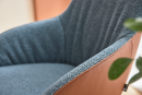 Moderner Sessel mit blauer Stoffpolsterung und brauner Lederseite, Nahaufnahme, stilvolles Wohnaccessoire.