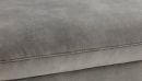 Grauer Polsterstoff in Nahaufnahme, weiche Textur, feine Naht, modernes Sofa-Design, hochwertige Verarbeitung.