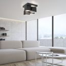 Modernes Wohnzimmer mit großer Fensterfront, heller Couch, runden Tischen und geometrischer Deckenleuchte.